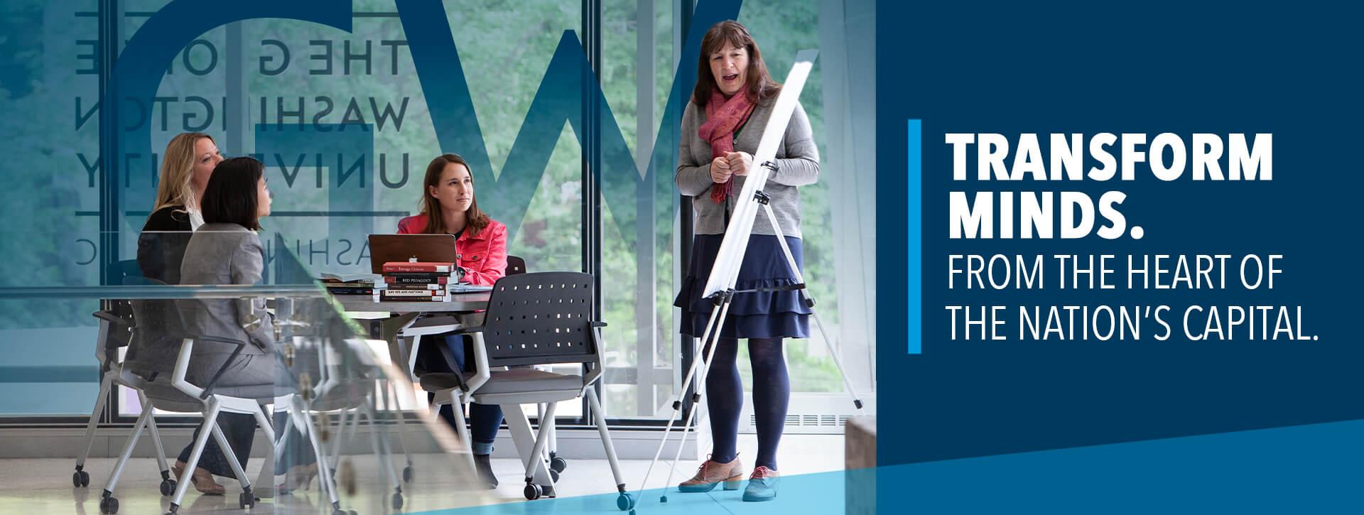 Transform Minds. From the Heart of the Nation's Capital. (image of professional female presenting information on a poster on an easel to a group of 3 professional females seated at a table)